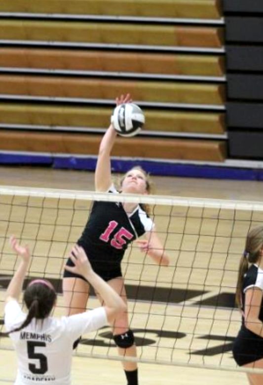 Volleyball player attacking the ball at the net